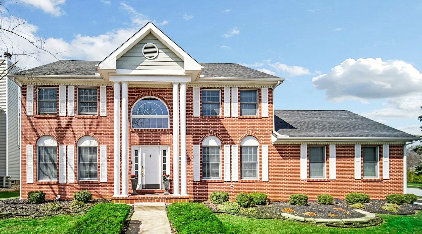 Beautiful two-story house with brick siding and roman columns in Schererville, IN.